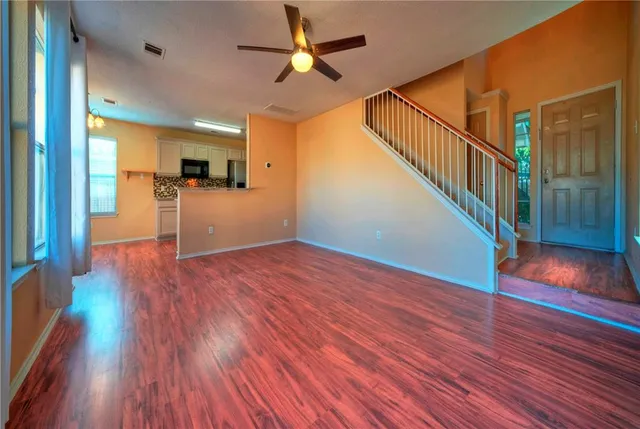 a view of empty room with wooden floor