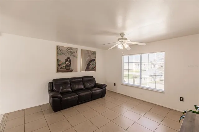 a living room with furniture and a ceiling fan