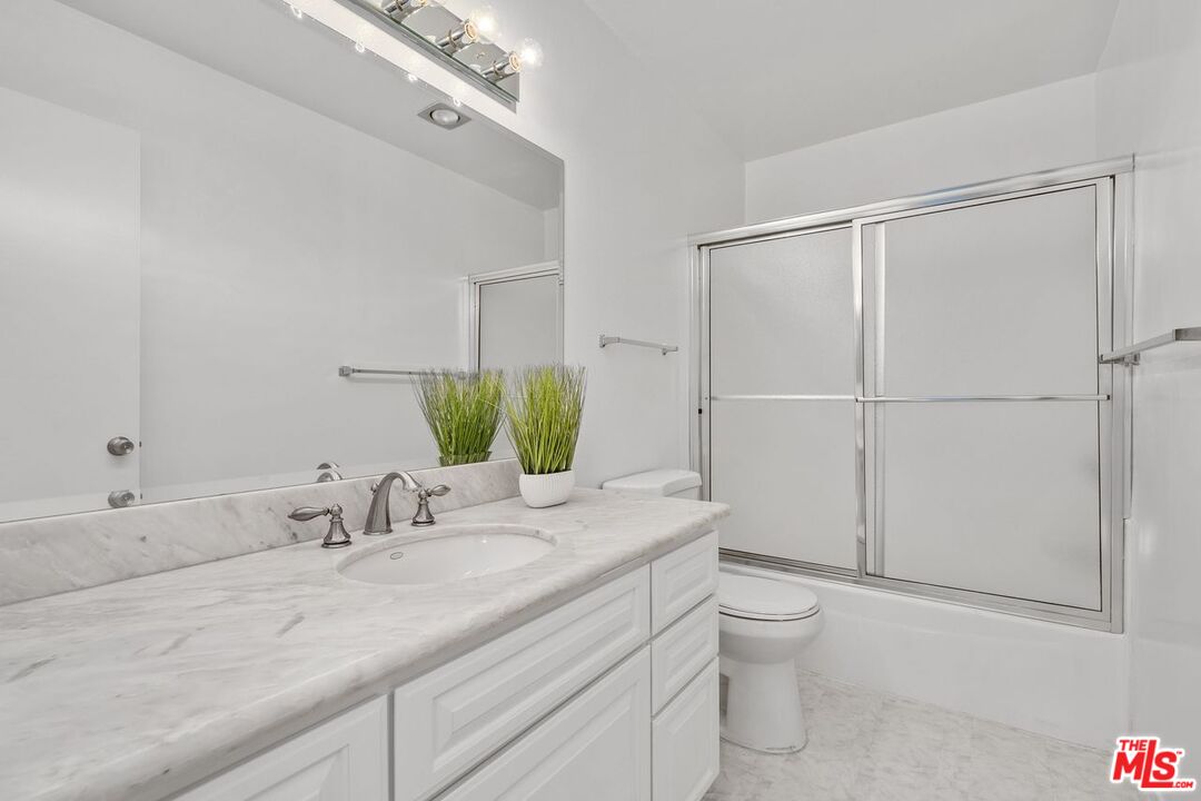 1211 Raintree Circle Culver City, CA 90230 - Photo 14 of 44 a bathroom with a granite countertop sink a toilet and mirror