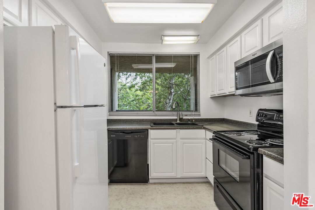 1211 Raintree Circle Culver City, CA 90230 - Photo 6 of 44 a kitchen with stainless steel appliances granite countertop a stove a refrigerator and a microwave