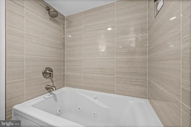 a bathroom with a white bath tub and a shower
