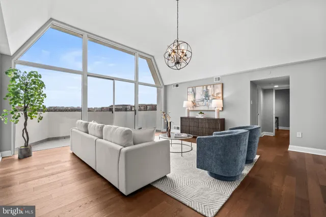 a living room with furniture wooden floor and a large window