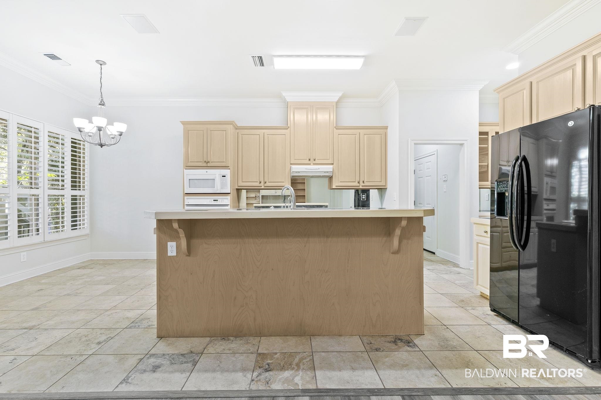 13 Bugle Retreat Daphne, AL 36527 - Photo 7 of 40 Kitchen with an inviting chandelier, a center island with sink, crown molding, decorative light fixtures, and black fridge with ice dispenser