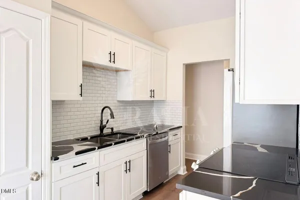 a kitchen with granite countertop a sink and a stove