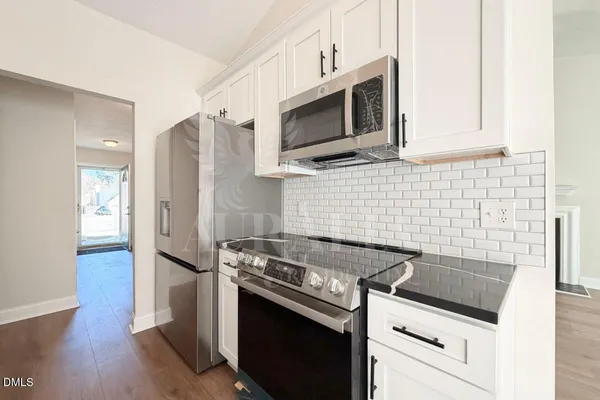 a kitchen with stainless steel appliances a stove a microwave oven cabinets and a counter top space