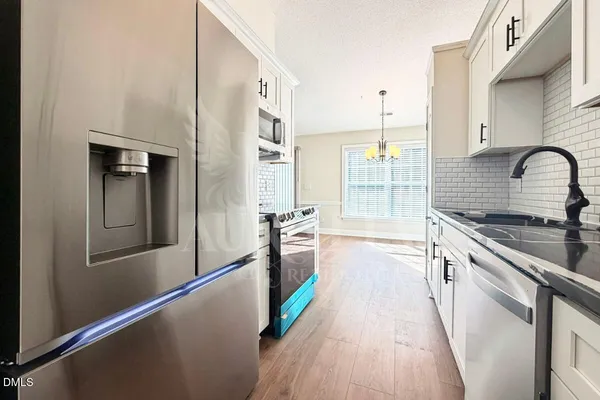 a kitchen with granite countertop a refrigerator and a sink