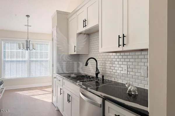 a view of a kitchen counter space a sink and appliances