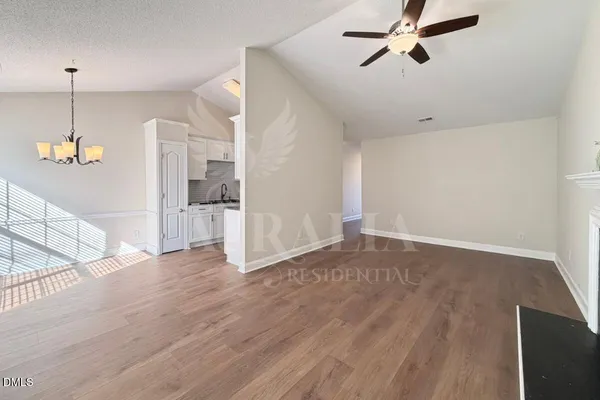 a view of a kitchen with wooden floor and a ceiling fan