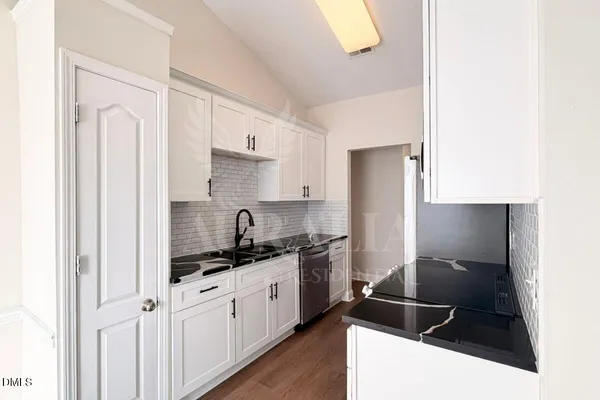 a kitchen with a sink and white cabinets