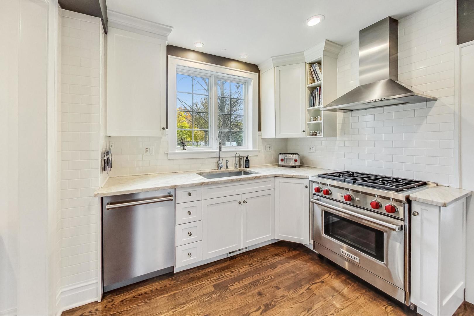 352 Addison Road Riverside, IL 60546 - Photo 14 of 63 a kitchen with stainless steel appliances a stove a sink and white cabinets