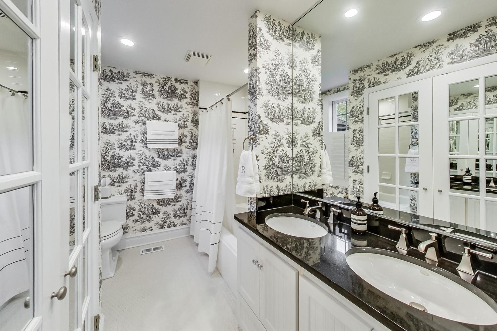 352 Addison Road Riverside, IL 60546 - Photo 23 of 63 a bathroom with a granite countertop double vanity sink a mirror a shower and a bathtub