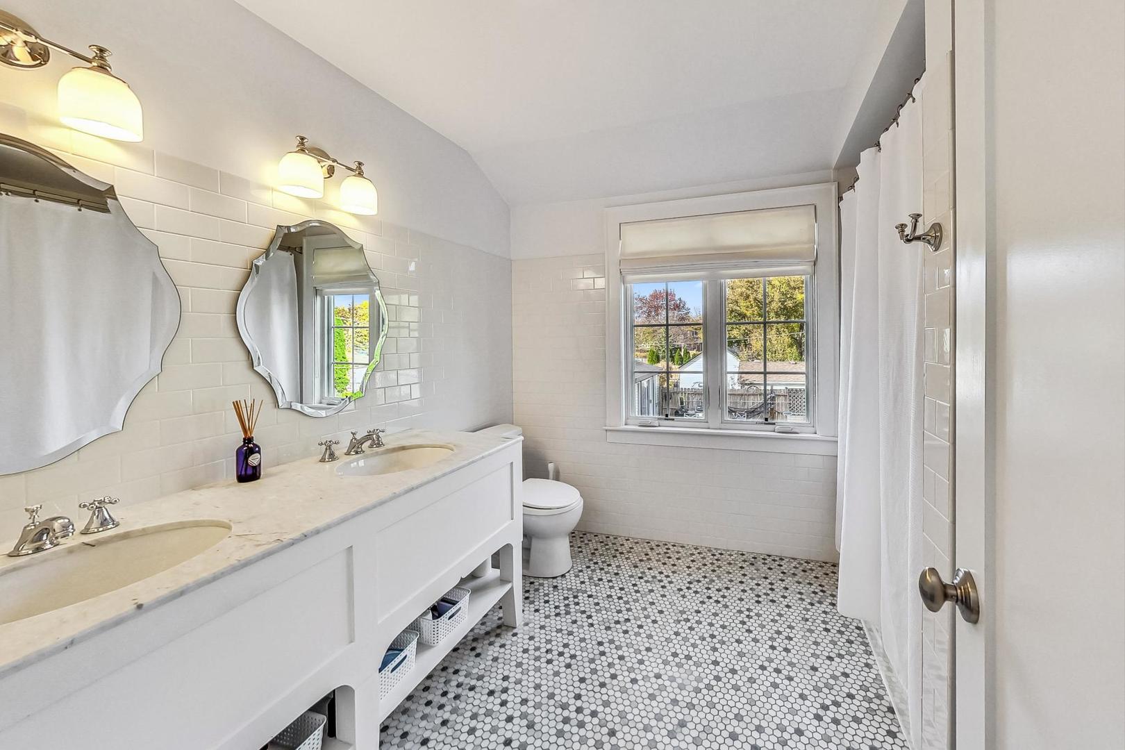 352 Addison Road Riverside, IL 60546 - Photo 42 of 63 a spacious bathroom with a double vanity sink toilet mirror and window