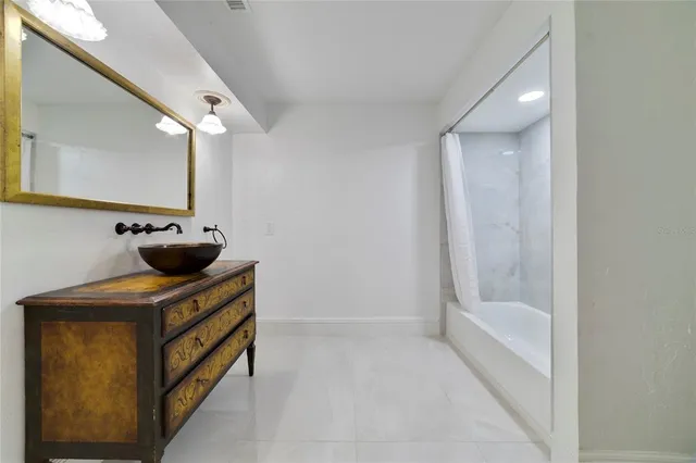 a bathroom with a sink a mirror and a bathtub