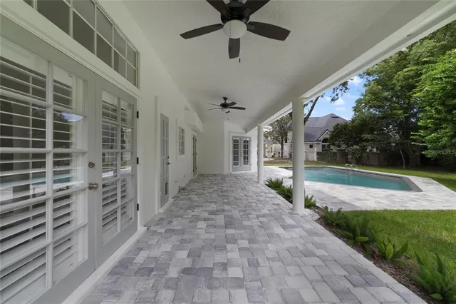 a view of a porch with a ceiling fan and a yard