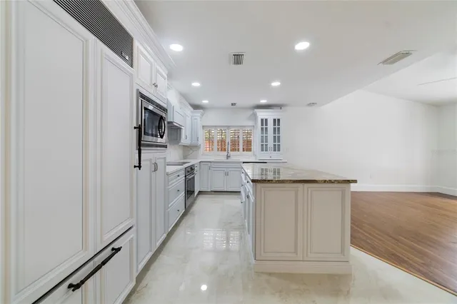 a kitchen with stainless steel appliances granite countertop a refrigerator and a sink
