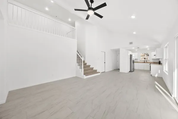 an empty room with a chandelier fan and closet