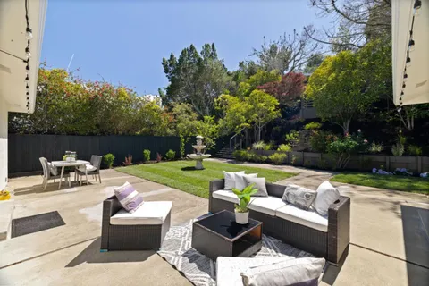 a view of a patio with couches chairs and a fire pit and an umbrella