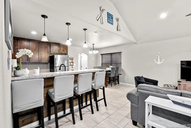 a kitchen with kitchen island granite countertop a table and chairs in it