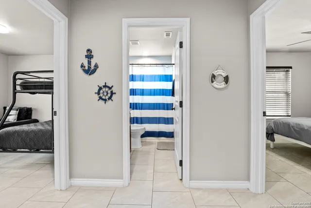 a kitchen with stainless steel appliances granite countertop a refrigerator a stove a sink a dining table and chairs with wooden floor