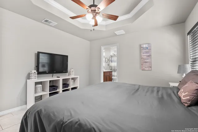 a spacious bedroom with a bed and a chandelier