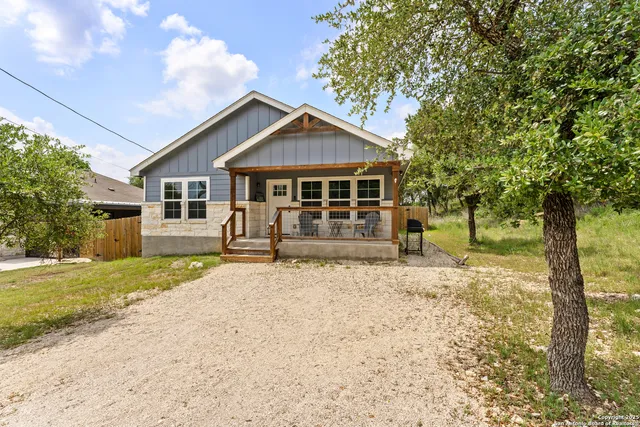 a view of a house with backyard and trees