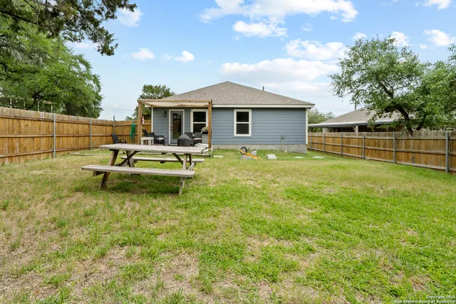 a backyard of a house with table and chairs
