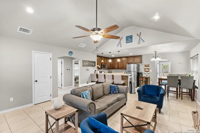 a living room with furniture kitchen view and a chandelier