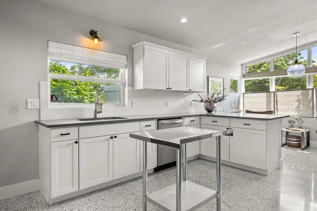 a kitchen with a sink window and cabinets