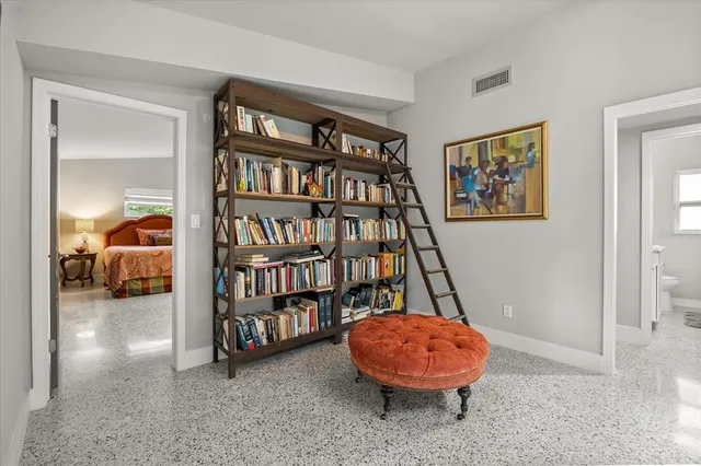 a living room with furniture and a book shelf