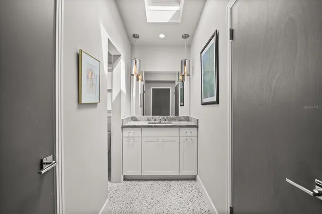 a bathroom with a granite countertop sink a mirror and vanity
