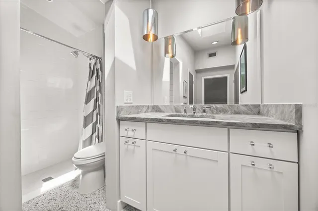 a bathroom with a sink a toilet and a mirror