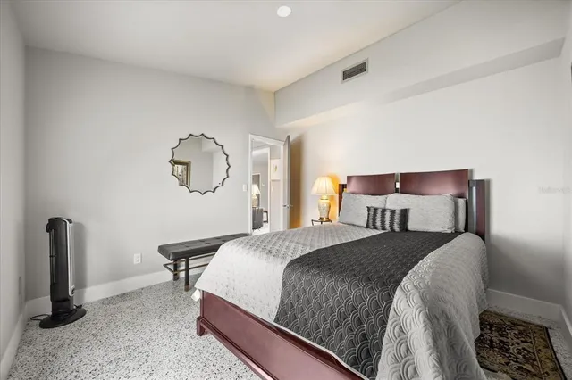 a bedroom with a bed a dresser and chair