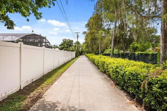an aerial view of residential houses with outdoor space and trees