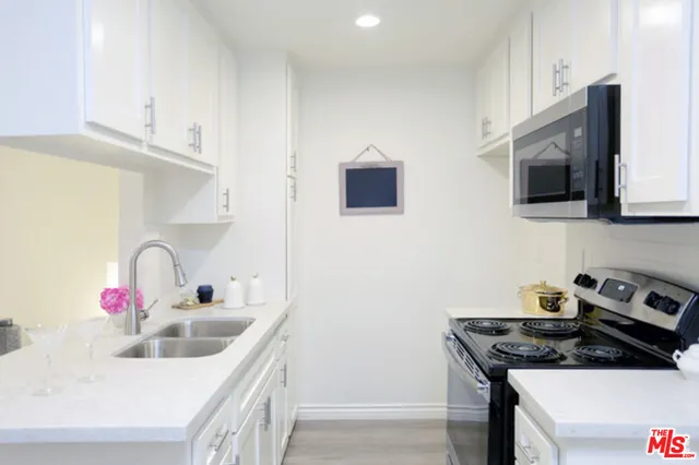 a kitchen with stainless steel appliances granite countertop a sink stove and microwave