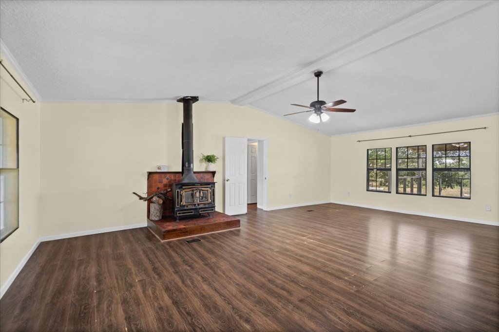 13501 Nutty Brown Road, Unit B Austin, TX 78737 - Photo 3 of 29 A spacious, airy living area features rich hardwood flooring and a warm wood-burning stove.
