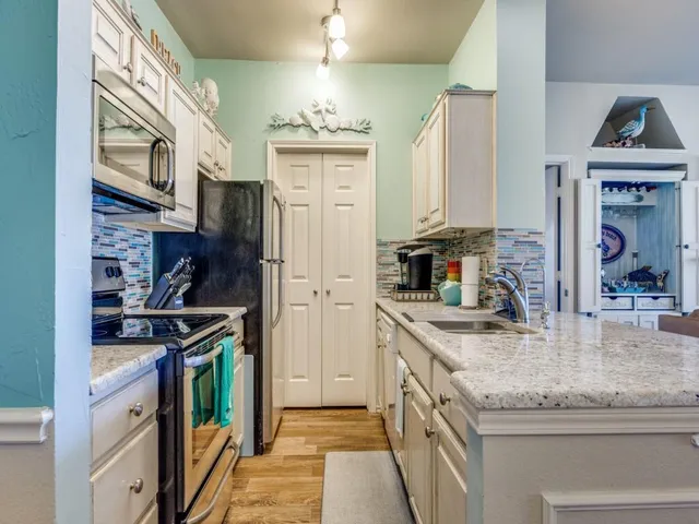 a kitchen with stainless steel appliances granite countertop a sink and a stove