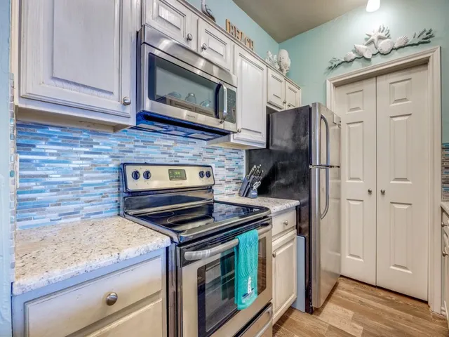 a kitchen with stainless steel appliances granite countertop a stove microwave and cabinets