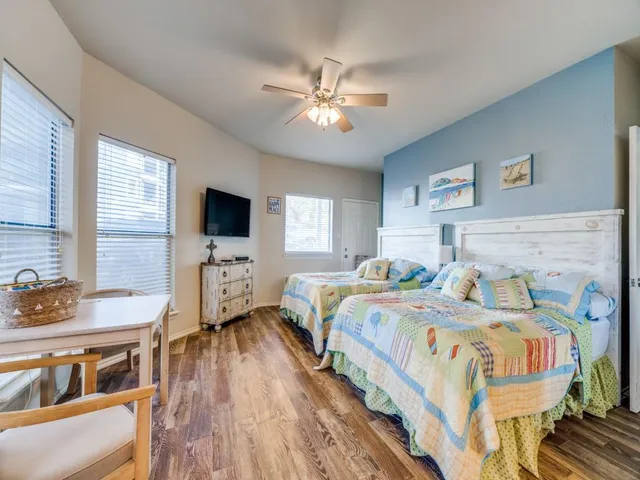 a bedroom with two beds and a flat screen tv