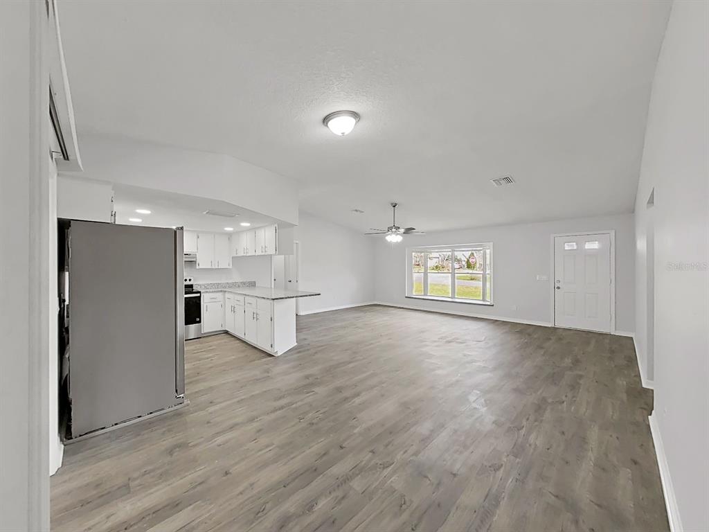 902 Great Pine Point Inverness, FL 34452 - Photo 11 of 39 a view of an empty room with a window and wooden floor