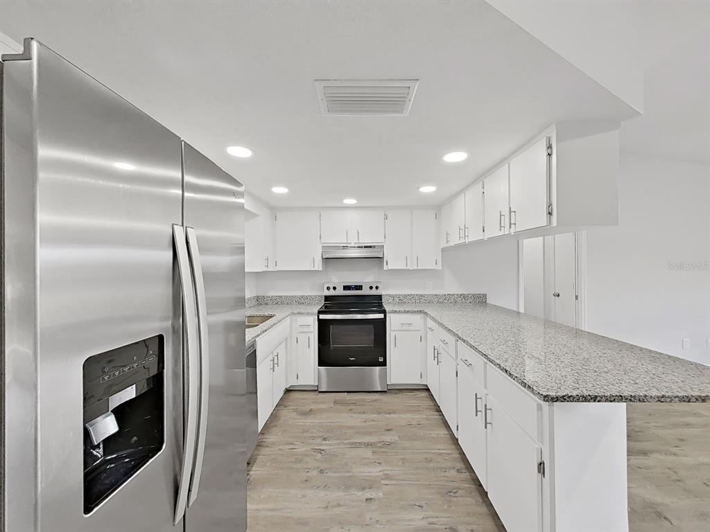 902 Great Pine Point Inverness, FL 34452 - Photo 14 of 39 a large kitchen with stainless steel appliances granite countertop a stove and a refrigerator
