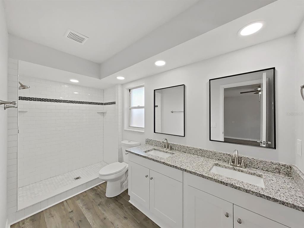 902 Great Pine Point Inverness, FL 34452 - Photo 23 of 39 a bathroom with a double vanity sink toilet mirror and shower