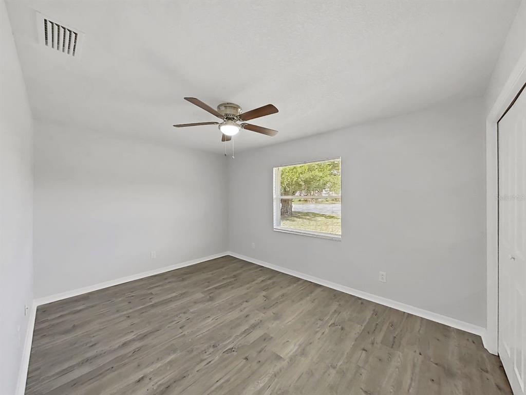 902 Great Pine Point Inverness, FL 34452 - Photo 25 of 39 an empty room with wooden floor fan and windows