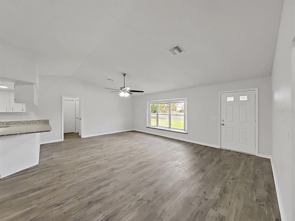 902 Great Pine Point Inverness, FL 34452 - Photo 9 of 39 an empty room with wooden floor and windows