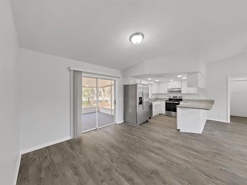 902 Great Pine Point Inverness, FL 34452 - Photo 10 of 39 a kitchen with a refrigerator and wooden floor