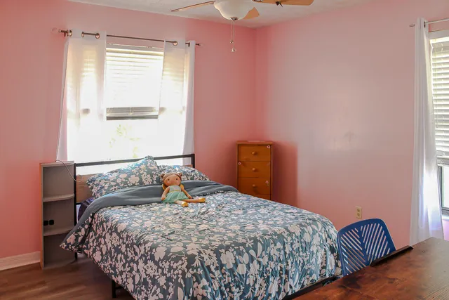 a bedroom with a bed and wooden floor