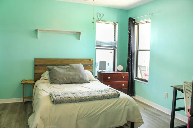 a bed sitting in a bedroom next to a window