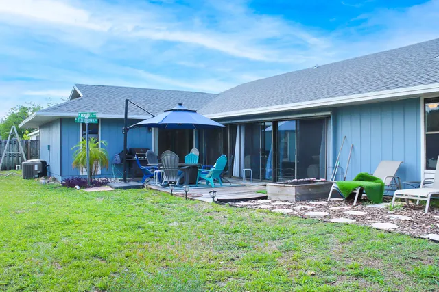 a view of a chair and table in backyard of the house