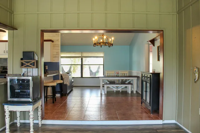 a dining room with wooden floor a chandelier a wooden table and chairs
