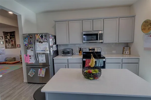 a kitchen with stainless steel appliances granite countertop a refrigerator and a stove top oven