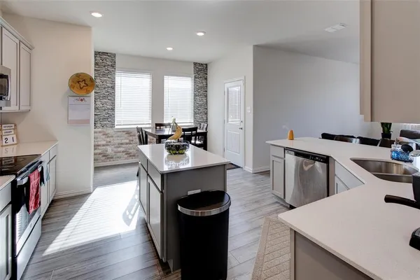 a kitchen with a sink stove and wooden floor